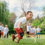 Kids enjoy outdoor fun with hula hoops in a vibrant park setting.